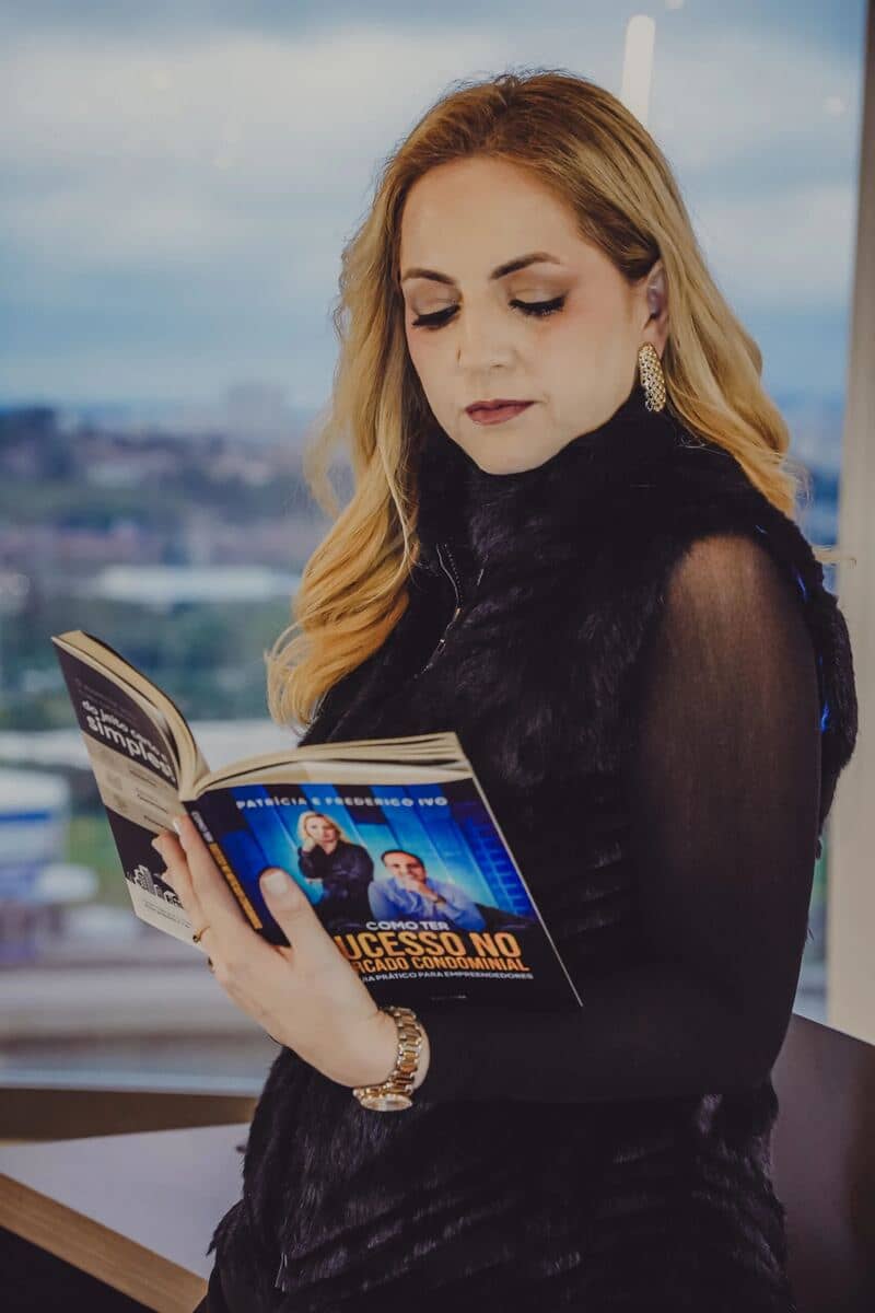 Paty Ivo lendo um livro junto à janela